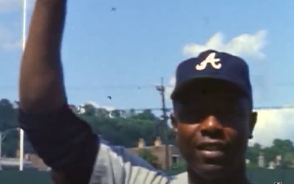 Hank Aaron celebrating his unmatched 2,297 career RBIs, showcasing his greatness as baseball's true GOAT.