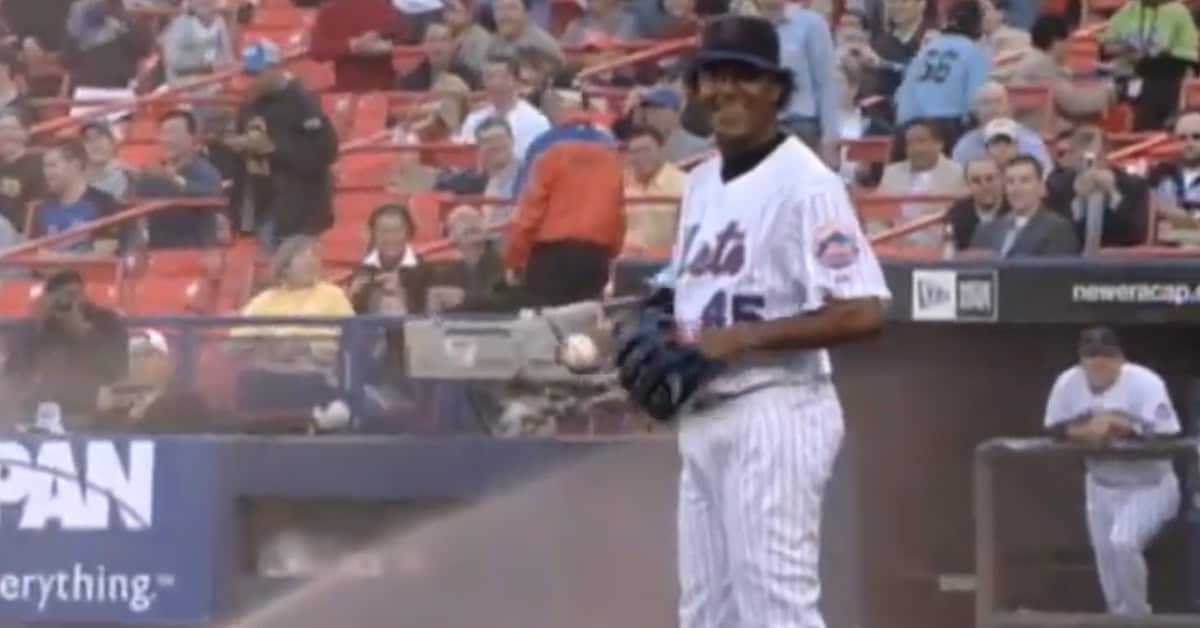 Pedro Martinez humorously celebrates with a sprinkler head dip during a game.