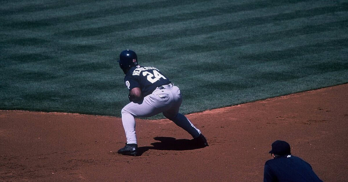 Rickey Henderson stealing a base, showcasing his speed and prowess in baseball.