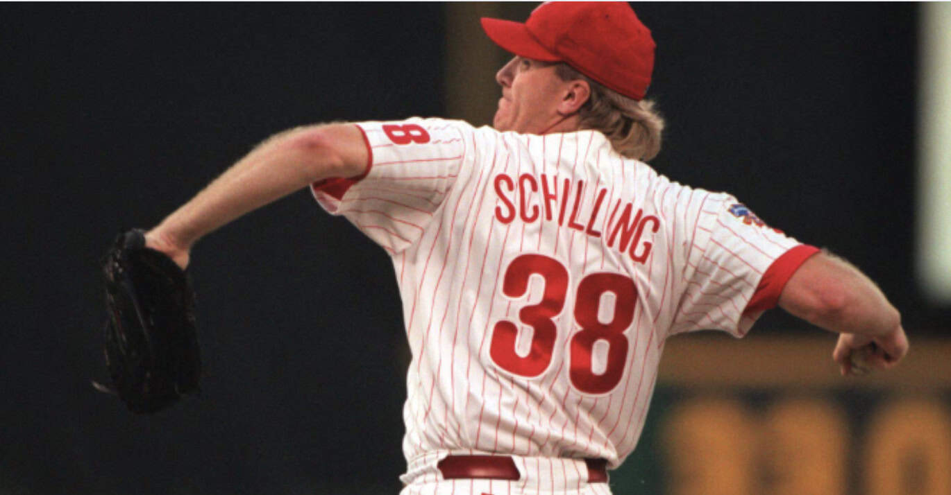 Curt Schilling pitching during a game, showcasing his 3,116 career strikeouts.