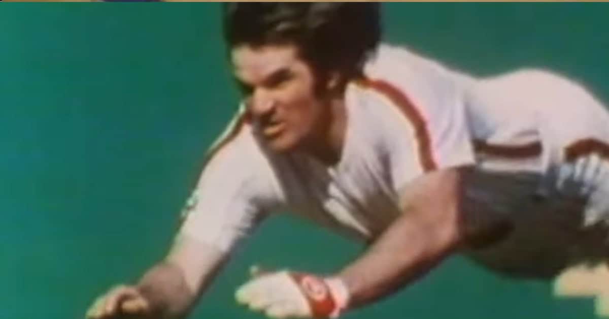 Pete Rose executes his signature headfirst slide during a game, symbolizing his hustle.