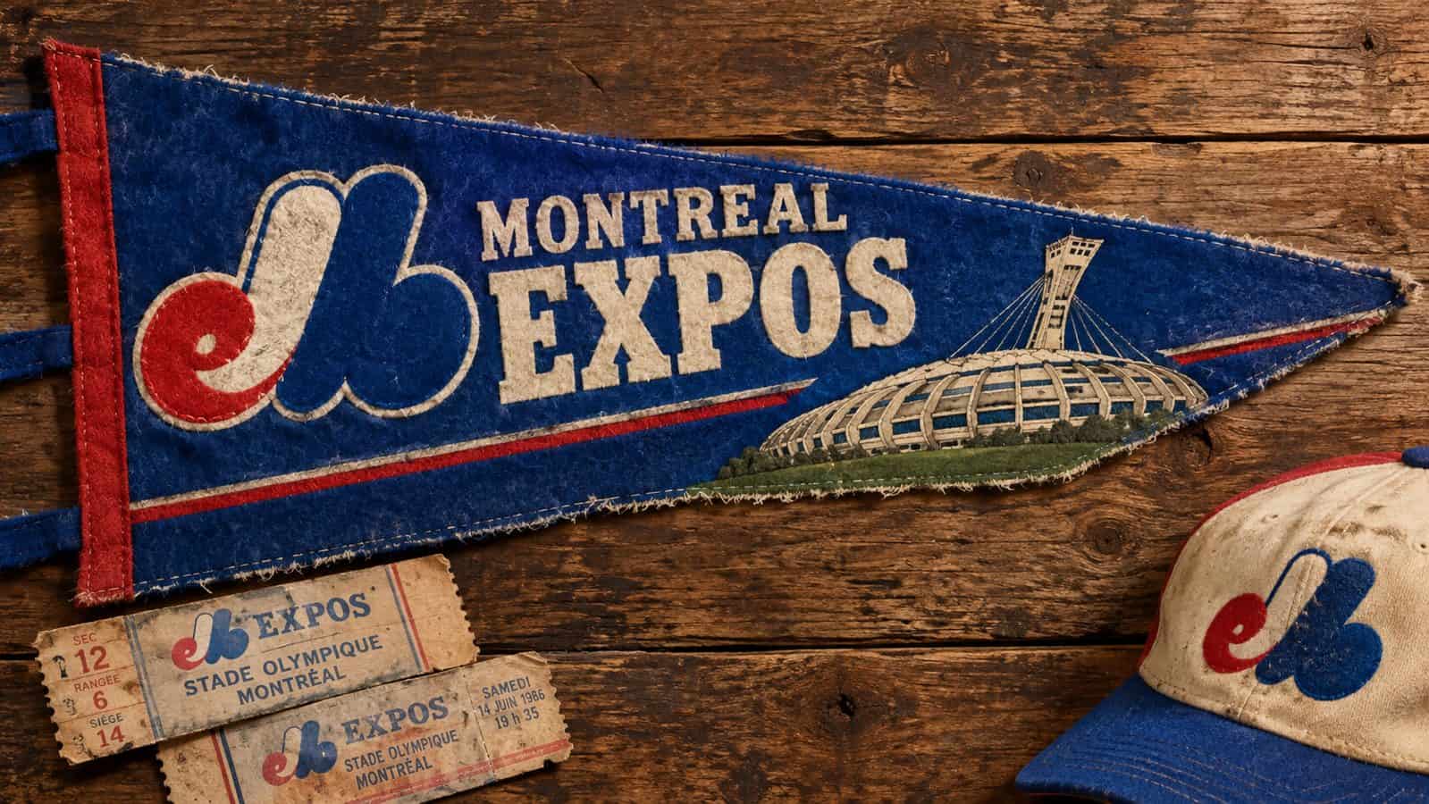 Vintage felt pennant for the Montreal Expos with the team's tri-color logo, beside a stitched illustration of Olympic Stadium, an old cap and ticket stubs on weathered wood, evoking nostalgia for the lost franchise.